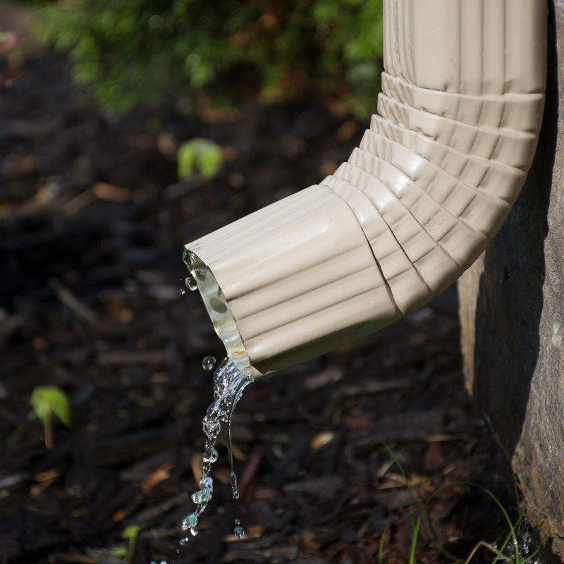 Downspout directing rainwater to reduce runoff in a residential landscape